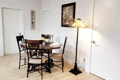 a dining room with a table and chairs and a lamp at Gorgeous 2 Bedrooms Suite Private entrance with patio-Free Parking in Maple Ridge District Municipality