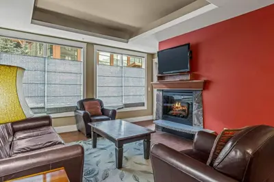 a living room with a fireplace and a tv at Luxury Resort 2Bedroom 2Bath Sleeps 6 945 square feet in Canmore