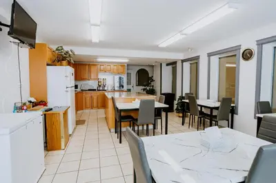 a kitchen and dining room with a table and chairs at Western Budget Plus Mosaic Suites in Red Deer