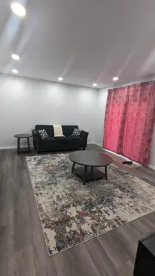 a living room with a couch and a table at Comfy one bedroom Airdrie in Airdrie