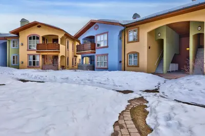 a pile of snow in front of a house at Crystal Forest #51 condo in Sun Peaks