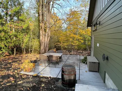 a patio with a table and chairs next to a house at Cowichan Valley Guest Cottage in Ladysmith