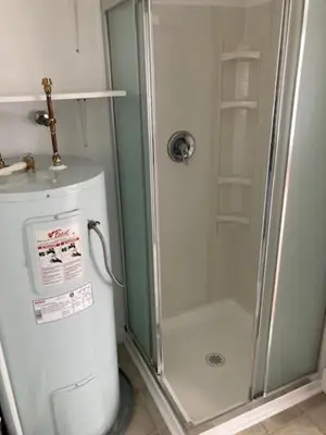a bathroom with a shower next to a refrigerator at Rent My Studio in Powell River