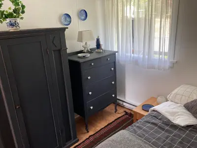 a bedroom with a black dresser next to a bed at Rent My Studio in Powell River