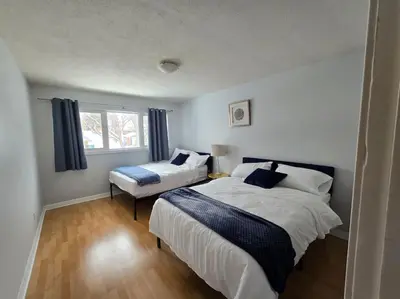 a bedroom with two beds and a window at 3 Bedroom Home away from Home in Calgary