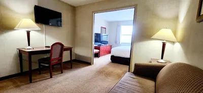 a hotel room with a bedroom with a desk and a bed at Park Hill Inn & Suite in Red Deer