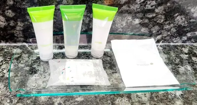 a glass table with four green plastic cups on it at Park Hill Inn & Suite in Red Deer