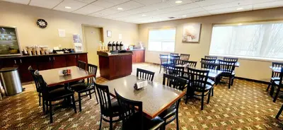 a dining room with tables and chairs in a restaurant at Park Hill Inn & Suite in Red Deer