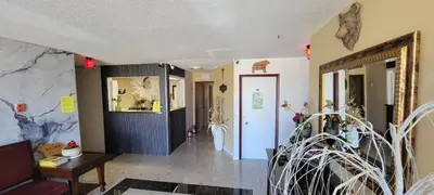 a living room with a hallway with a table and chairs at GRIZZLY MOTEL in Swan Hills