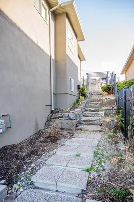 a stone path next to a house with a fence at Lakeview 2-bed 2-bath Entire Suite near Summerhill Winery in Kelowna