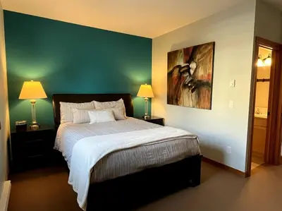 a bedroom with a bed and a painting on the wall at L202 - A Relaxed Vacation- 2BD+2BT, Heated Pool, Hot tubs, Gym, AC, Parkade in Canmore