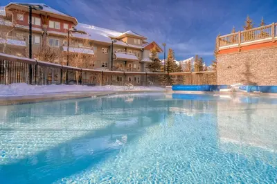 a large pool of water in front of a building at L202 - A Relaxed Vacation- 2BD+2BT, Heated Pool, Hot tubs, Gym, AC, Parkade in Canmore
