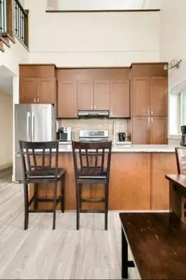 a kitchen with two chairs and a refrigerator at Lakeview Splendor- 7BR Penthouse Bliss Combo unit in Harrison Hot Springs