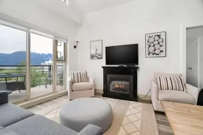 a living room with a fireplace and a tv at Lakeview Splendor- 7BR Penthouse Bliss Combo unit in Harrison Hot Springs