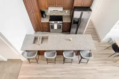 a kitchen with a counter with chairs around it at Lakeview Splendor- 7BR Penthouse Bliss Combo unit in Harrison Hot Springs