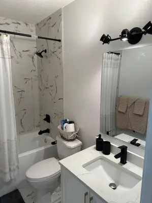 a white bathroom with a toilet and a sink at Guest suite in Southwest Calgary in Calgary