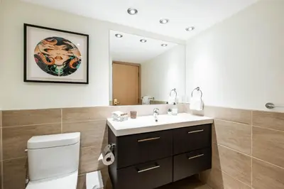 a bathroom with a sink and a toilet and a mirror at Le Chamois by Outpost Whistler in Whistler