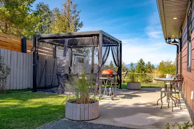 a patio with a tent and a table and chairs at The Nest in Lantzville
