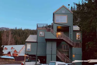 a green house with stairs on the side of it at Ski nest 5m to Creekside Gondola in Whistler
