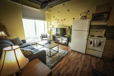 a living room with a couch and a refrigerator at 2 Full Beds, Rogers Place Downtown Central, Memorable 1 Bedroom Condo in Edmonton
