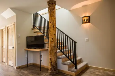 a spiral staircase in a home with a tv and a stair case at Cabins West in Ucluelet