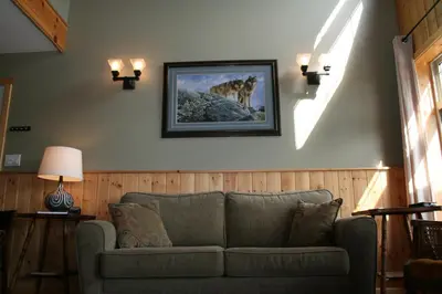 a living room with a couch and a picture on the wall at Cabins West in Ucluelet