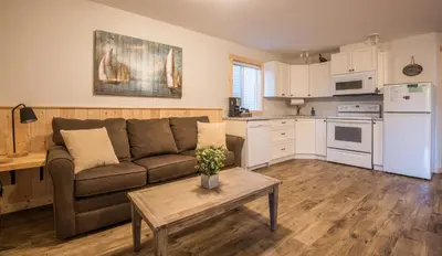 a living room with a couch and a table at Cabins West in Ucluelet