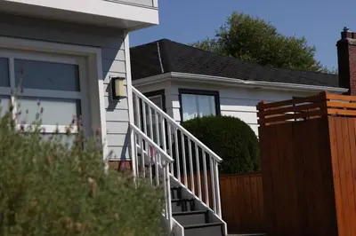 a house with a white railing and a wooden fence at Location, Location, Location-Immaculate 1 Bedroom Suite in Victoria