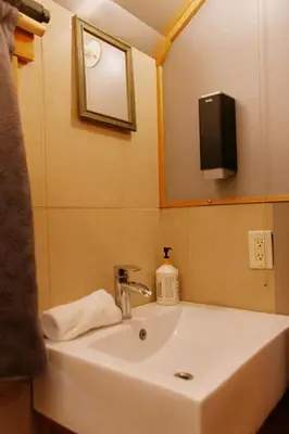 a bathroom sink with a mirror and a tv on the wall at Rustic Beaverfoot Lodge in Parson