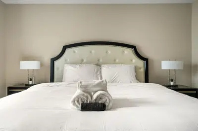 a bedroom with a white bed with two lamps at 5 Bedroom House in McConachie, Near Anthony Henday, Sleeps 12, Backyard, Netflix, Free Parking in Edmonton