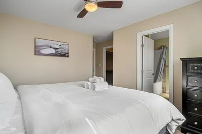 a bedroom with a white bed with a ceiling fan at 5 Bedroom House in McConachie, Near Anthony Henday, Sleeps 12, Backyard, Netflix, Free Parking in Edmonton