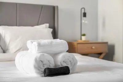 a pile of towels sitting on top of a bed at Prime Location Near Jasper Ave with Downtown Views, Netflix, Gym, Sauna, Sleeps 4 in Edmonton