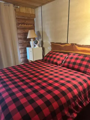 a red and black checkered bed in a bedroom at Anglemont Inn in Anglemont
