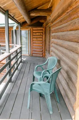 two green chairs sitting on the porch of a cabin at Anglemont Inn in Anglemont