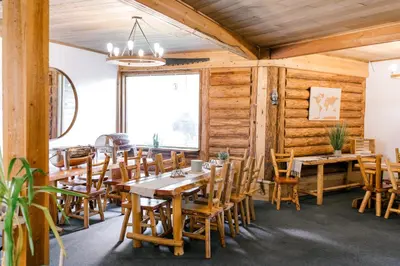 a dining room with wooden walls and tables and chairs at Anglemont Inn in Anglemont