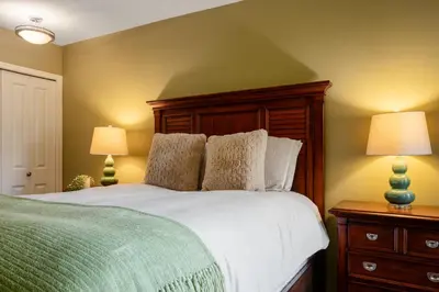 a bedroom with a large white bed with two lamps at 3BR in Wintergreen, Family Sized, Wood Burning Fireplace, Secure Parking, Ski Hill Bus Access in Whistler