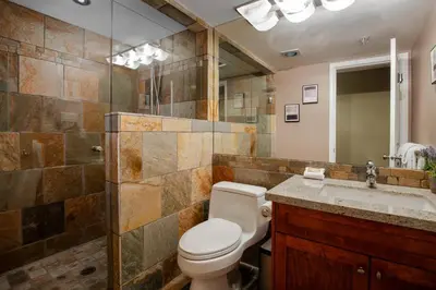 a bathroom with a toilet and a sink and a mirror at 3BR in Wintergreen, Family Sized, Wood Burning Fireplace, Secure Parking, Ski Hill Bus Access in Whistler