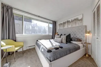 a bedroom with a large bed and a yellow chair at 1Bd Unit In the heart of Whistler Village in Whistler