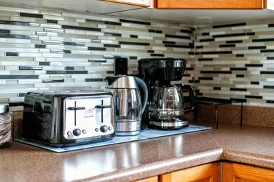 a kitchen counter with two coffeemakers on a counter top at Comfy Getaway - Walk to West Ed Mall in Edmonton