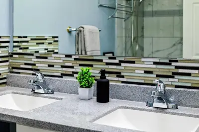a bathroom counter with two sinks and a mirror at Comfy Getaway - Walk to West Ed Mall in Edmonton