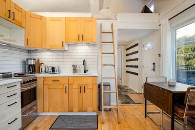 a kitchen with wooden cabinets and a ladder at 1BR plus Loft in Gondola Village, Creekside, Amazing Patio with Views, Near Gondola, Free Parking in Whistler