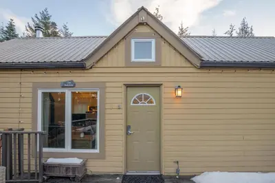 a yellow house with a door and a window at 1BR plus Loft in Gondola Village, Creekside, Amazing Patio with Views, Near Gondola, Free Parking in Whistler