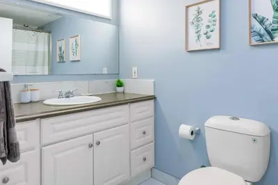 a bathroom with a white toilet and a sink at Cozy Suite - Walk to West Ed Mall in Edmonton