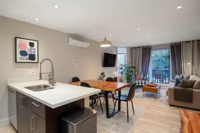 a kitchen and living room with a table and a dining room at 1BR plus Two Dens in The Gables, Epic Location Near Gondolas, Private Balcony, Fireplace, Parking in Whistler
