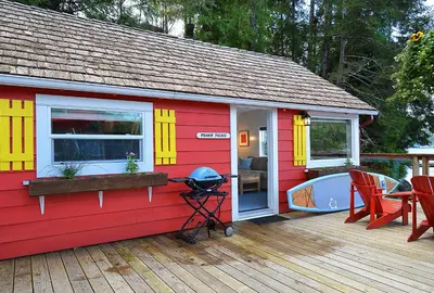 a red and yellow house with a grill on a deck at John Henry's Marina and Resort in Garden Bay