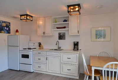 a kitchen with white cabinets and a white refrigerator at John Henry's Marina and Resort in Garden Bay