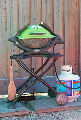 a grill sitting on a stand next to a fence at John Henry's Marina and Resort in Garden Bay