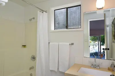 a bathroom with a tub and a sink and a window at John Henry's Marina and Resort in Garden Bay