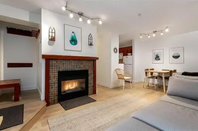 a living room with a fireplace and a dining room at Cozy Townhouse in Whistler Village North in Whistler