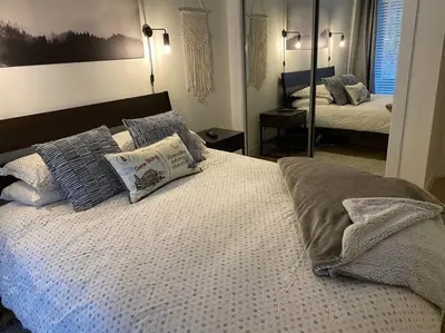 a bedroom with a bed with pillows and a mirror at Cozy Townhouse in Whistler Village North in Whistler
